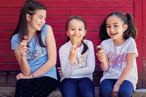 Portrait of girlfriends eating ice cream and having fun together Portrait of girlfriends eating ice cream and having fun together stealing ice cream stock pictures, royalty-free photos & images