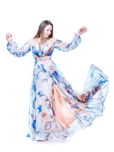 istock Girl in a long chic dress dancing on a white background 1223950971