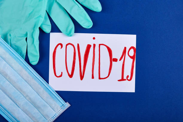 istock Coronavirus phrase text flat lay on blue background, gloves protective face mask 1223952852
