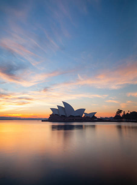 Sydney Australia - April 02, 2016: Early morning in Sydney, and the iconic Opera House and a glorious pre-dawn sky are reflected in the waters of Circular Quay.