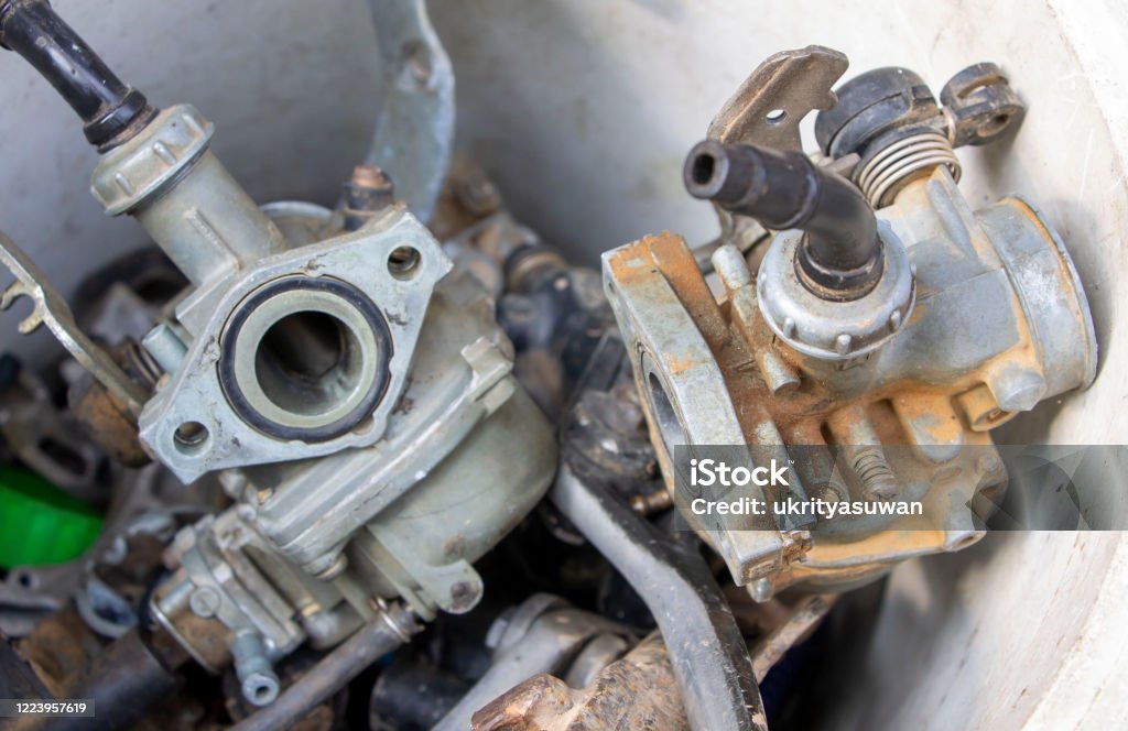 Carburators used carburators in a plastic tank. Carburetor Stock Photo