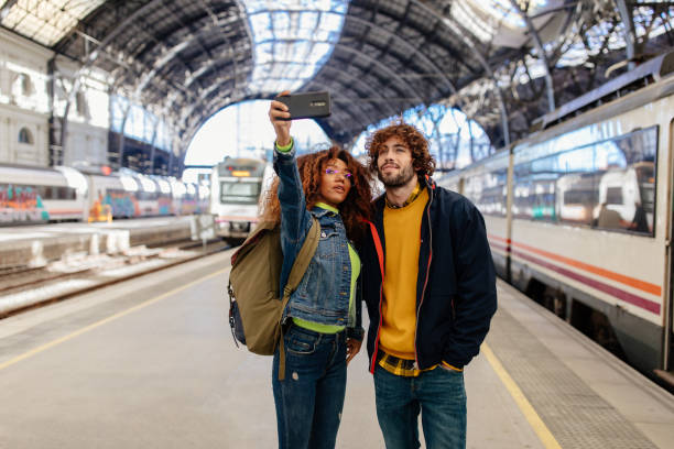 istock Young multi-ethnic couple taking selfie with smartphone at train station 1223958615