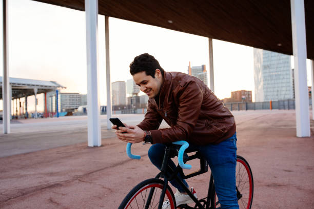 istock Young man checking his smartphone on top of bicycle 1223958815