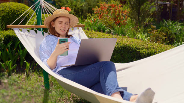 istock woman lies in hammock and working on computer 1223959174