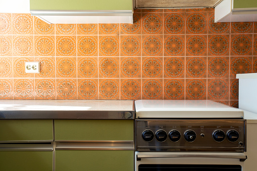 Vintage retro kitchen with orange pattern tiles, american retro kitchen home interior design 70's style close-up