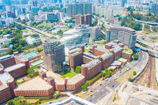 View of Osaka city from the top of Osaka Castle with green gardens, buildings, and sky, with a brown building in the foreground.