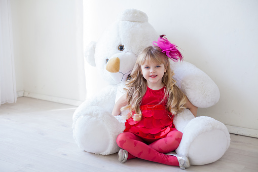 Beautiful girl with toy big teddy bear