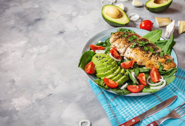 istock Grilled chicken breast and avocado salad with spinach and cherry tomatoes on concrete background. Healthy food, ketogenic diet. Copy space 1223963929