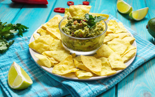 istock Nachos. Tortilla Chips with Guacamole on blue wooden background 1223964105