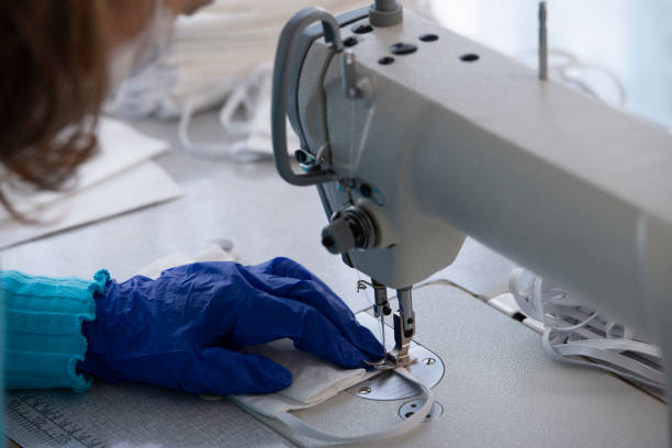istock Textile industry seamstress sewing surgical masks. 1223964348