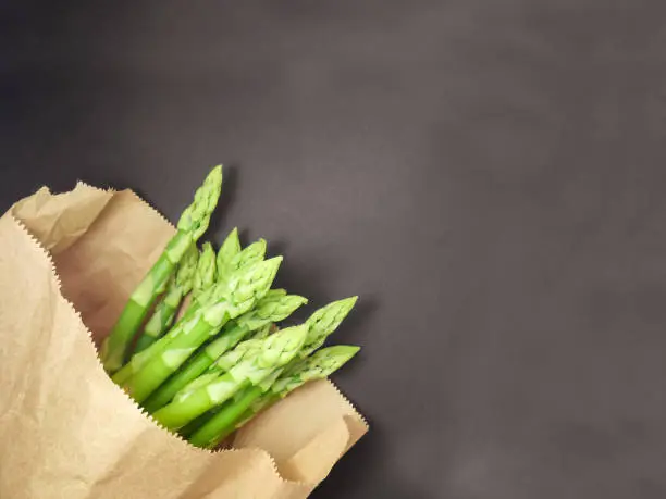 Raw asparagus in paper bag. Fresh green Asparagus.