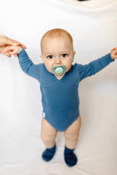 istock 8 month baby try to stand on foot 1223964515