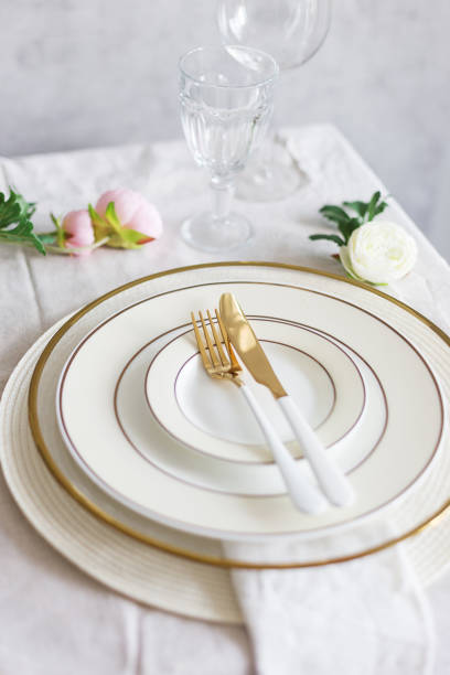 istock Golden fork and knife on empty light white and golden plates with golden tableware. close up, copy space, banner, blank. Concept of table set for holiday as Christmas, Chinese New year or wedding 1223967416