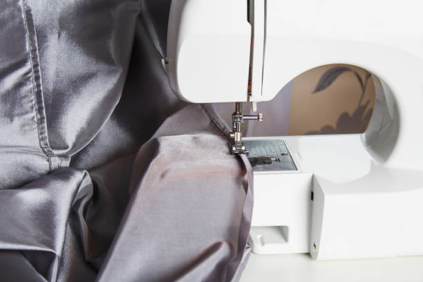 istock A man hem a curtain on a sewing machine. Sewing, hobbies, hobby, home improvement. 1223969554