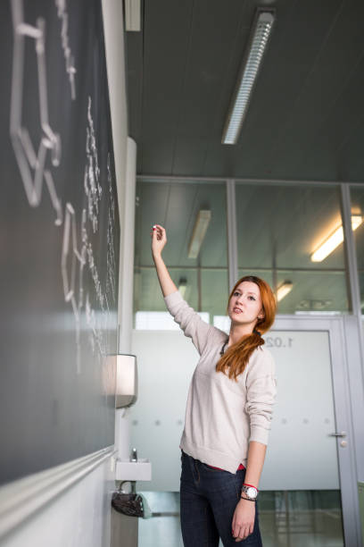 istock Pretty young college student writing on the chalkboard/blackboard 1223970985