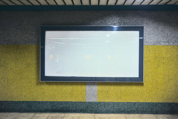 istock Empty white billboard on a yellow and gray colored wall at metro corridors 1223974214