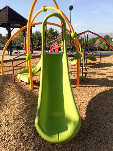 istock New modern Playground equipment green plastic slide at park school 1223977407