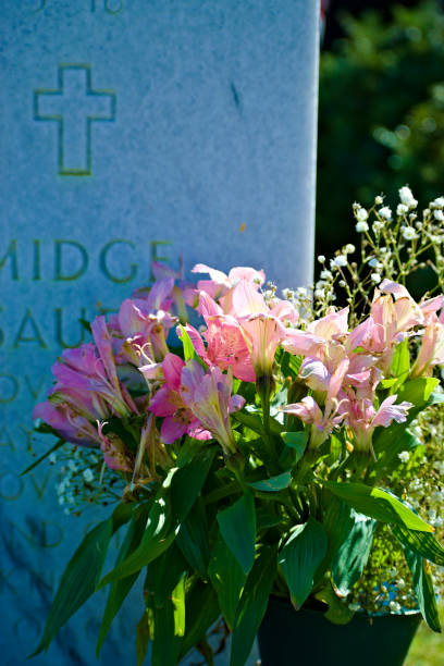 flores arregladas por las lápidas en el cementerio - cemetery grave military beauty in nature fotografías e imágenes de stock