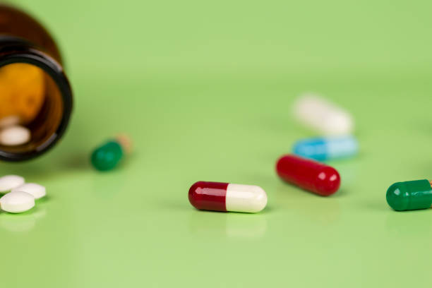 istock Different medications. Glass pill bottles. Green backdrop. 1223979126
