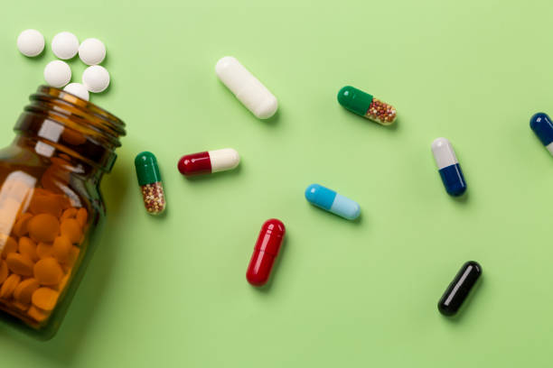 istock Different medications. Glass pill bottles. Green backdrop. 1223979132