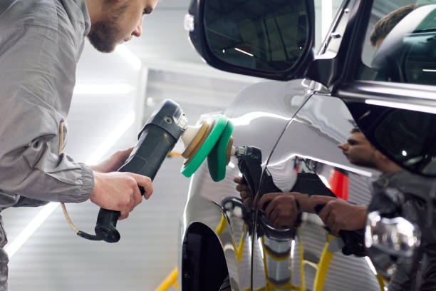 istock Man using polisher to polish black car body in the workshop 1223981643
