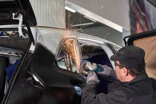 Cutting metal part with sparks in car service station