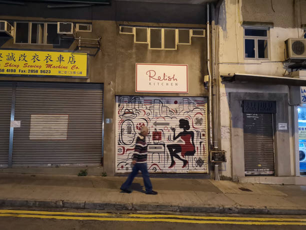 homme marchant dans sai ying pun, île de hong kong - graffiti paintings men walking photos et images de collection