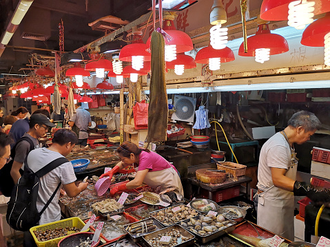 People shopping at a fresh seafood stall in Sai Ying Pun market, Western District, in the northwestern part of Hong Kong Island.