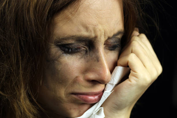 istock crying girl with smeared mascara on a black background 1223989196