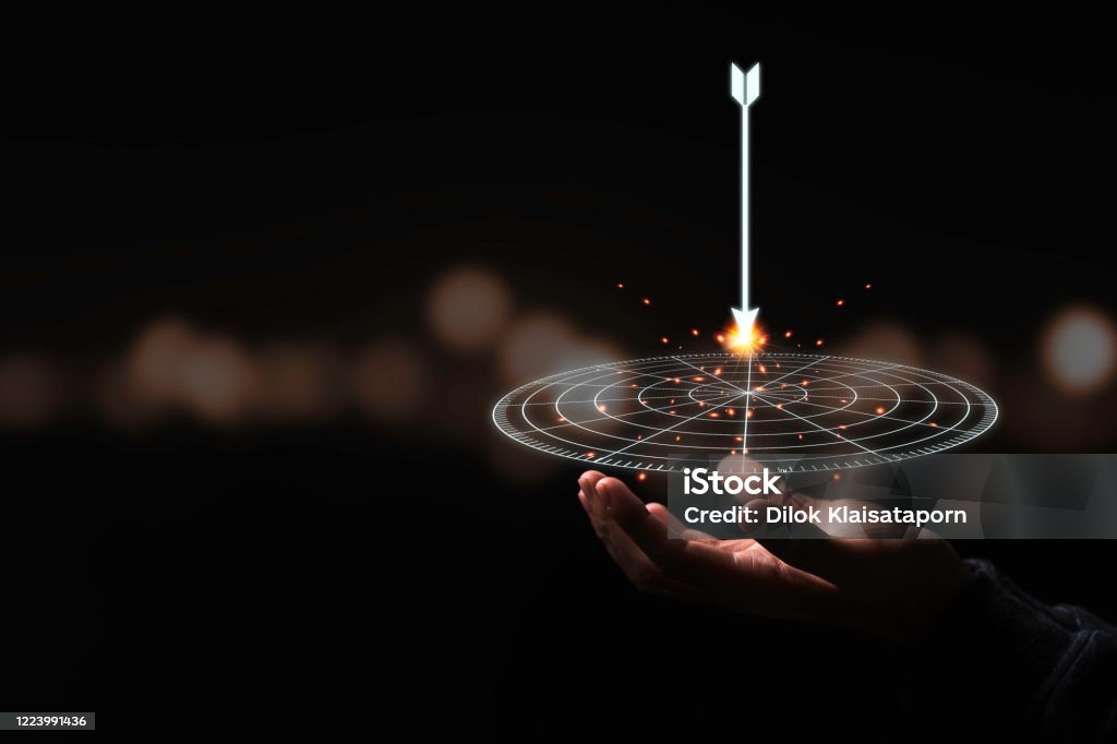 Hand holding virtual target board and arrow with bokeh background. Keeping and setup objectives and target for business investment concept. Aspirations Stock Photo