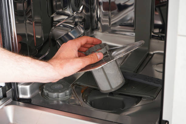 Cleans the filter in the dishwasher. Home appliance maintenance. Home appliance maintenance. A man cleans the filter in the dishwasher. dishwasher stock pictures, royalty-free photos & images