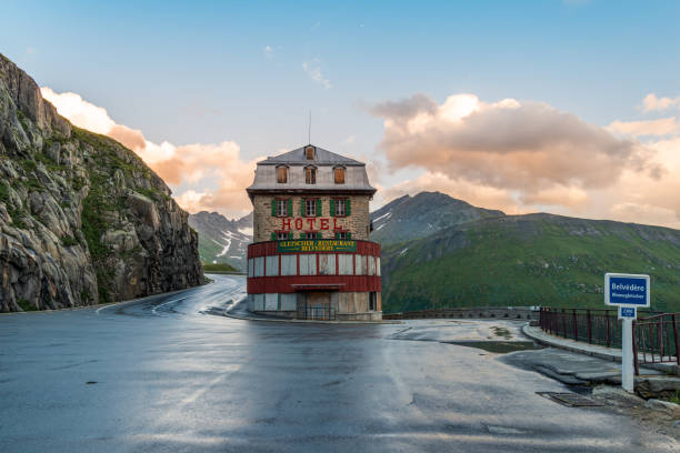 famous Hotel and Restaurant Belvédère with sharp hairpin and city sign at the Furka Pass street. stock photo