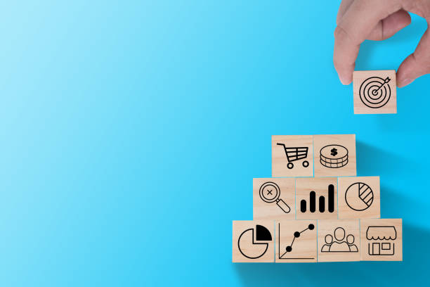 istock Hand putting target icon print screen on wooden cube to stack on other investment icon such as graph , dollar coin and trolley cart. Business investment concept. 1223993922