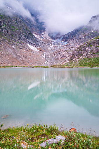Clouds move deep into the glacier with its blue ice. Reflections in the glacial lake. A paradise 4 nature lovers and hikers in the lovely Swiss Alps, Stein Glacier, 3863 Gadmen, Canton Bern, Switzerland
