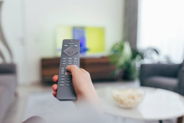 istock Woman looking the tv at home 1223996068