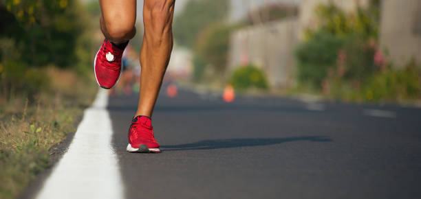 istock Fast strong runner feet running on asphalt road 1223997107