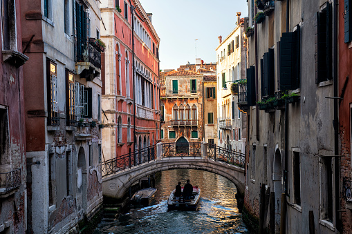 Venice, Italy - May 20, 2018. Two people riding a small boat in Venice, Italy.