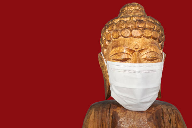 istock Buddha wooden statue wearing face mask 1224002678