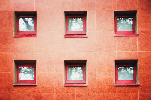istock Fragment of a red wall with windows. Front view. A strict laconic style. 1224005154