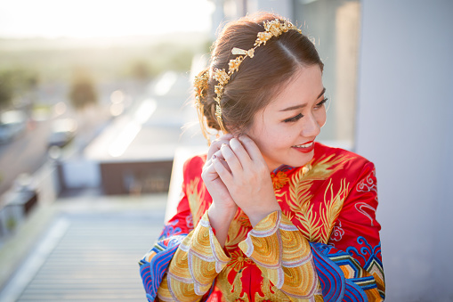 An Asia Chinese bride is preparing her wedding. She is wearing Chinese style wedding gown.