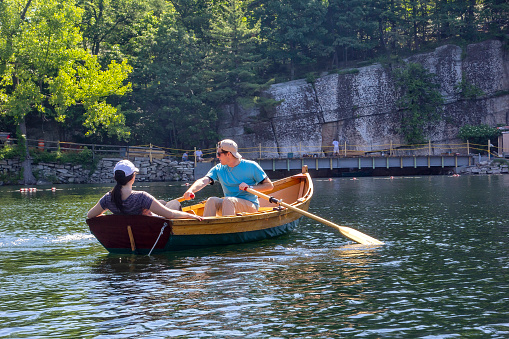 New Paltz, New York - June 22, 2014:  Young couple navigate a row boat in Lake Mohonk, a Victorian style hotel nestled in the Shawangunk Mountain Ridge.