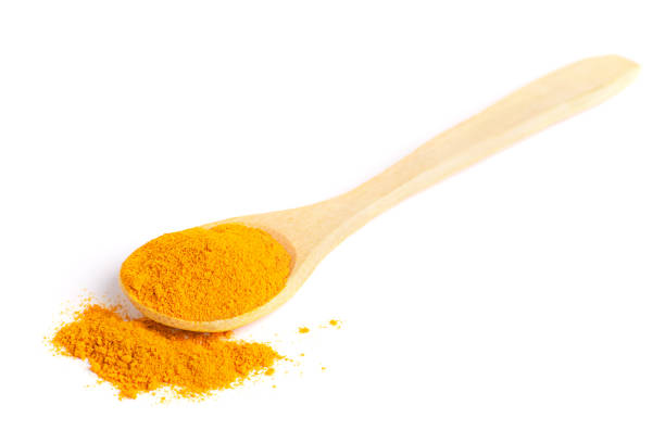 istock Isolated wooden spoon with scattered turmeric powder. 1224005649