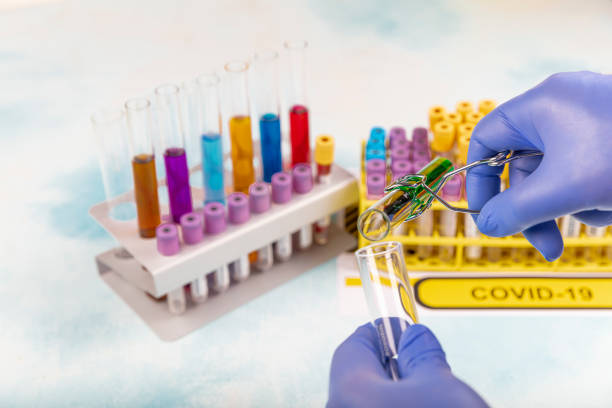 istock Conceptual photograph – Coronavirus testing: A hand holds a test tube containing a patient’s sample that has tested positive for coronavirus (COVID-19). 1224007773