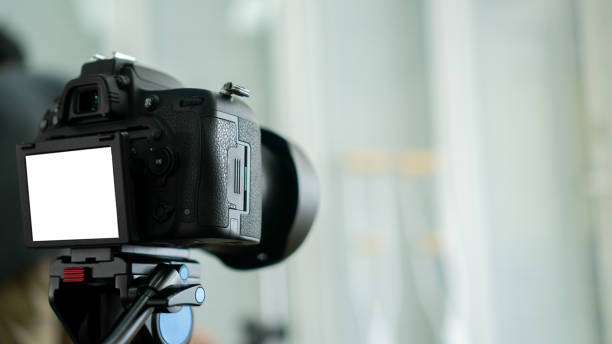 istock close up on DSLR camera standing and recording or set for photography with white mockup screen in studio concept 1224009673