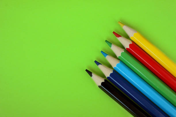 kolorowe ołówki na zielonym tle. 6 kolorów czarny, niebieski, niebieski, zielony, czerwony, żółty. ołówki są dobrze szlifowane. flatlay. odizolowany. sztuka. arteterapia. wypoczynek. ołówki są umieszczane w prawym dolnym rogu - flatey zdjęcia i obrazy z banku zdjęć