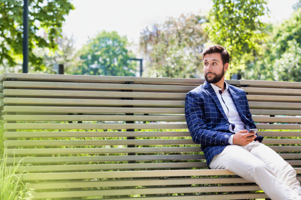 istock Portrait of young attractive businessman using smartphone while sitting on bench 1224014752