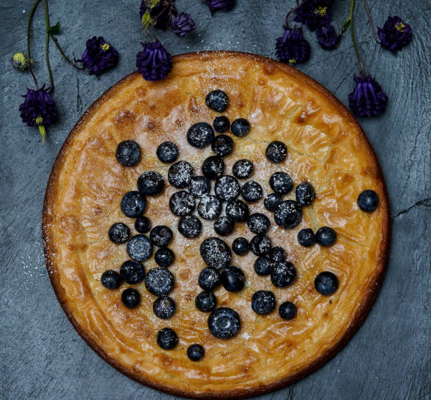istock Home made white chocolate cake, decorated with blueberries on a black plate. 1224019365