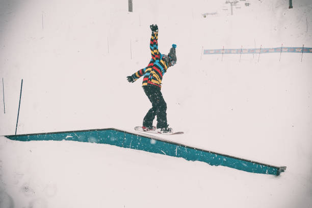 istock Freerider snowboarder doing basic snowboard rails trick in freestyle snowpark 1224019436