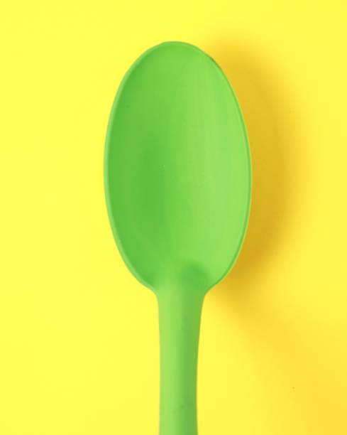 istock large green plastic spoon on yellow background close-up 1224021510