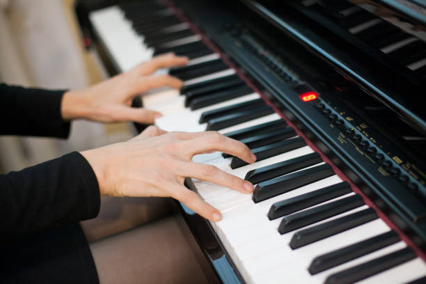 istock Crop of hands playing on piano from side perspective 1224023485